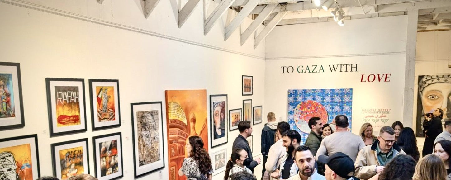 Crowd gathers at a vibrant gallery opening for "To Gaza With Love," featuring framed Palestinian artwork on white walls, including pieces labeled “RAFAH” and Dome of the Rock–inspired paintings. A colorful circular tile piece and the Gallery Habibi logo appear in the background.