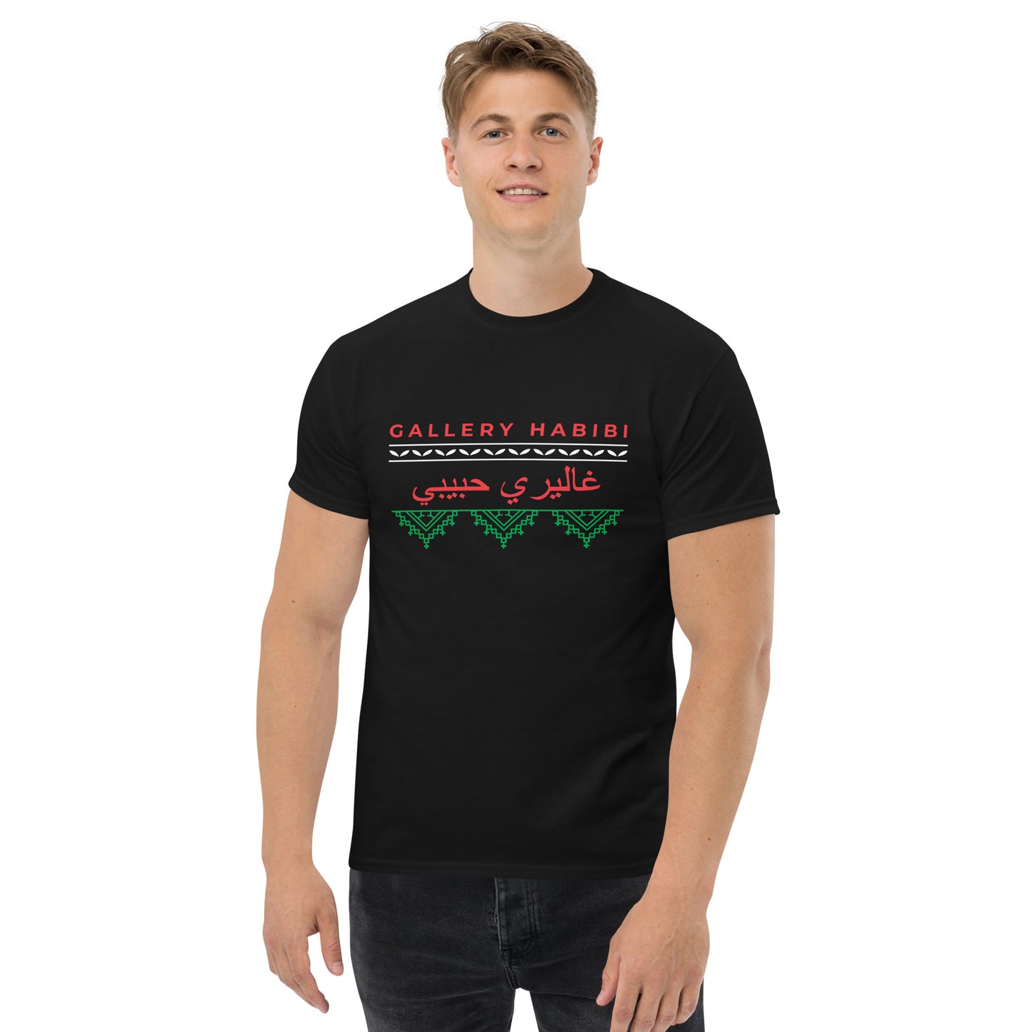 Person wearing black t-shirt featuring the classic Gallery Habibi logo with Arabic calligraphy and green Palestinian tatreez embroidery design