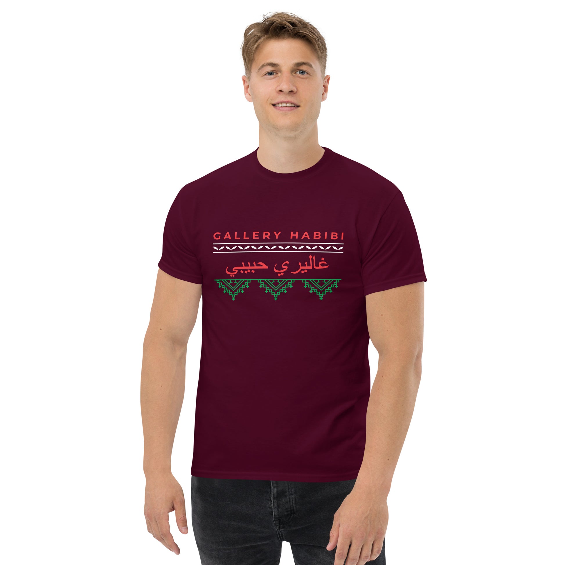 Man wearing maroon t-shirt with the classic Gallery Habibi logo, Arabic calligraphy, and green Palestinian tatreez embroidery